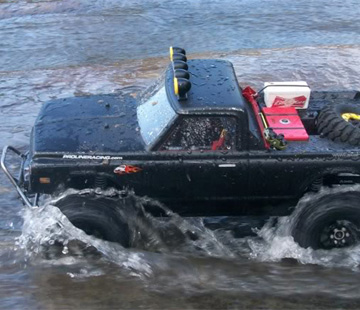 Mit mibenco Modellbau Farben schwarz lackiertes Modellauto fährt durchs Wasser
